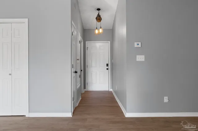 a view of a hallway with wooden floor and glass door