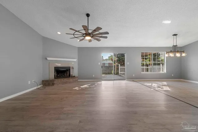 a view of an empty room with a fireplace and a window