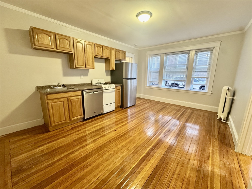1615 Commonwealth Avenue, Unit 6 Boston, MA 02135 - Photo 2 of 11 a view of a kitchen with wooden floor and stainless steel appliances