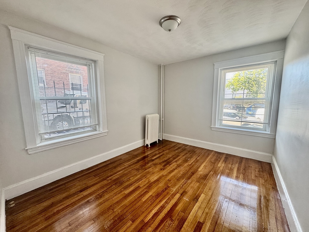1615 Commonwealth Avenue, Unit 6 Boston, MA 02135 - Photo 4 of 11 a view of an empty room with wooden floor and a window