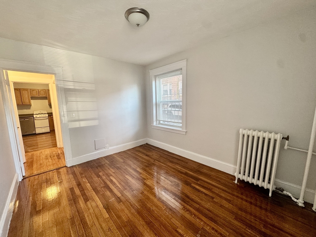 1615 Commonwealth Avenue, Unit 6 Boston, MA 02135 - Photo 5 of 11 an empty room with wooden floor and windows