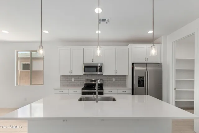 a kitchen with stainless steel appliances a refrigerator sink and microwave