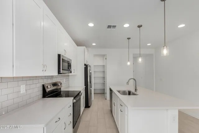 a kitchen with a sink a stove a refrigerator and cabinets