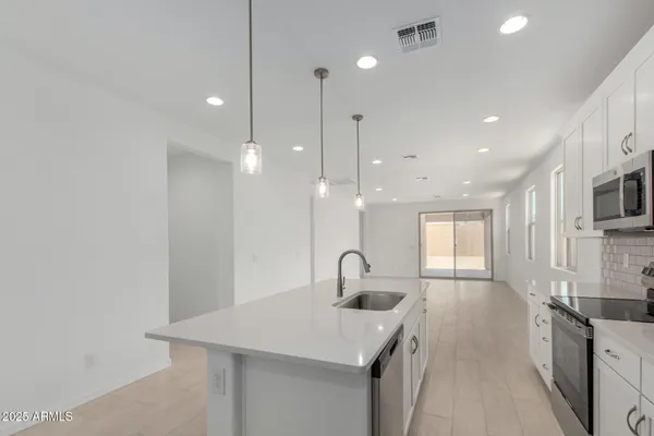 a kitchen with stainless steel appliances granite countertop a sink a stove and a wooden floors