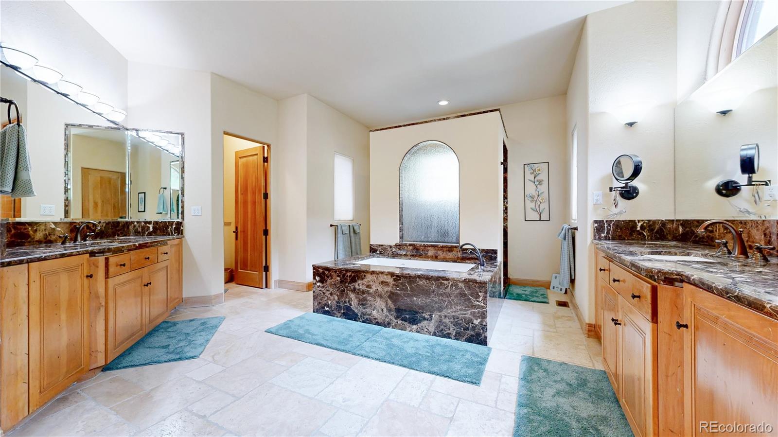 974 Spring Ranch Drive Golden, CO 80401 - Photo 19 of 50 a large bathroom with a granite countertop double vanity sink and a mirror