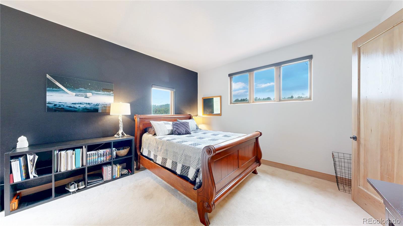 974 Spring Ranch Drive Golden, CO 80401 - Photo 23 of 50 a bedroom with a bed and a bookshelf with wooden floor