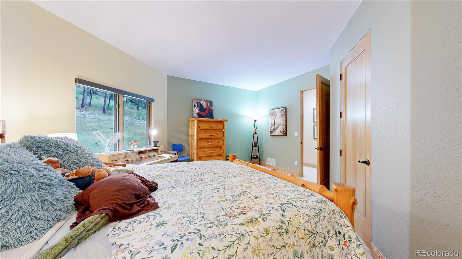 974 Spring Ranch Drive Golden, CO 80401 - Photo 25 of 50 a bedroom with a bed and a dresser next to a window