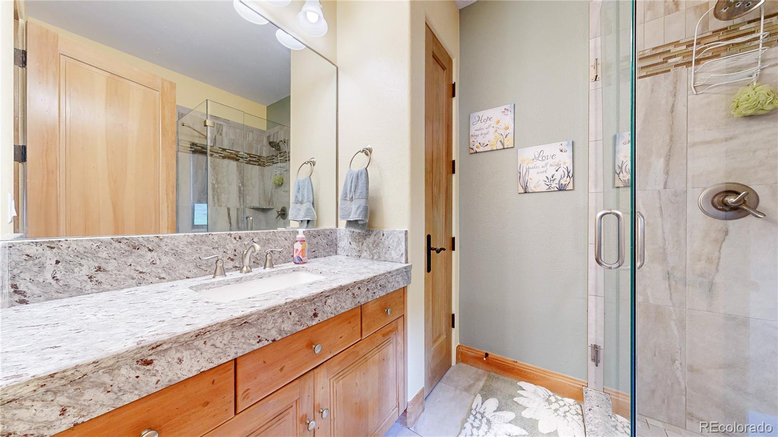 974 Spring Ranch Drive Golden, CO 80401 - Photo 26 of 50 a bathroom with a granite countertop sink and a mirror