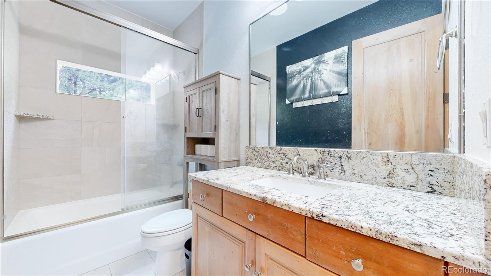 974 Spring Ranch Drive Golden, CO 80401 - Photo 33 of 50 a bathroom with a granite countertop sink and a mirror a toilet