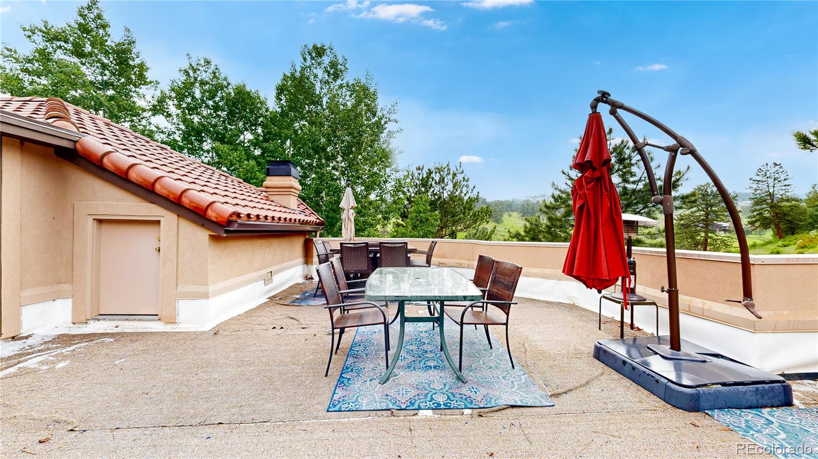 974 Spring Ranch Drive Golden, CO 80401 - Photo 42 of 50 a view of a patio with a dining table and chairs with wooden floor and fence