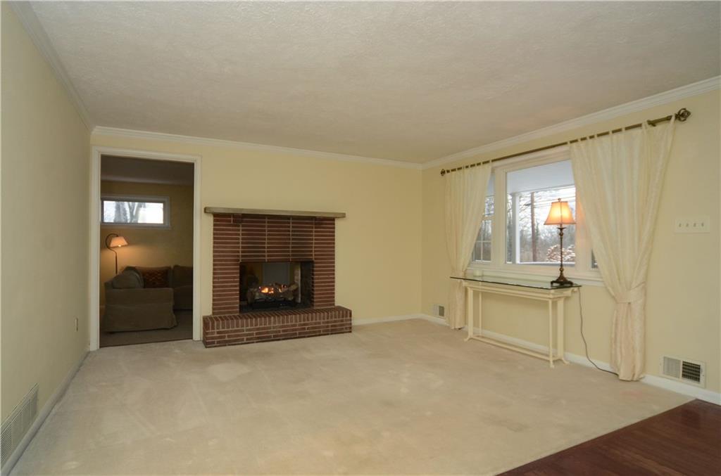 Living room that shares a pass through gas log fireplace with the family room.