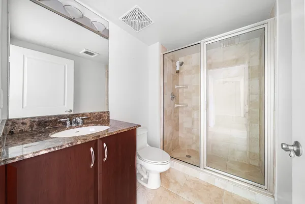 a bathroom with a granite countertop sink toilet and shower