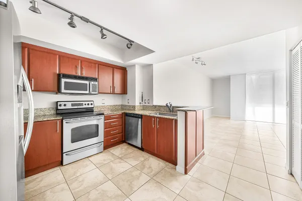 a kitchen with stainless steel appliances granite countertop a stove a sink and a microwave
