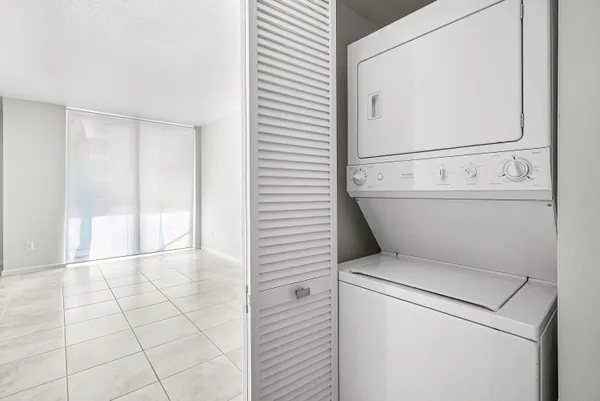 a view of washer and dryer with bathroom in the background