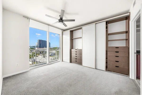 a view of an empty room with kitchen view
