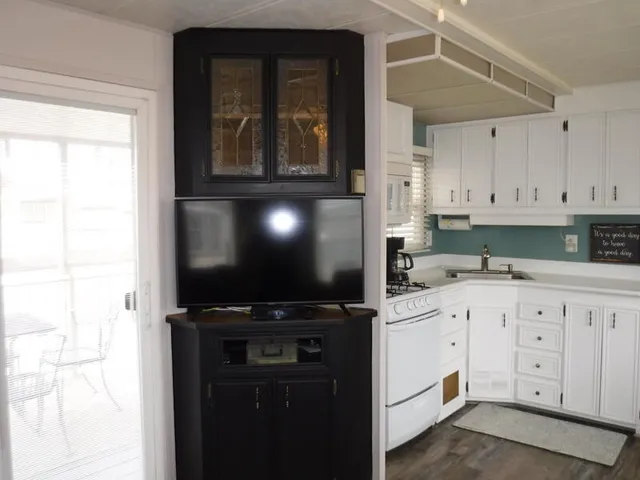 a kitchen with granite countertop a stove a sink and a microwave