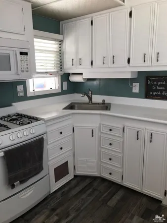 a kitchen with stainless steel appliances granite countertop a sink a stove and a window