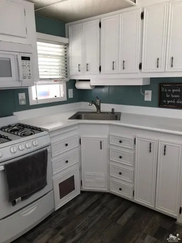 a kitchen with stainless steel appliances granite countertop a sink a stove and a window