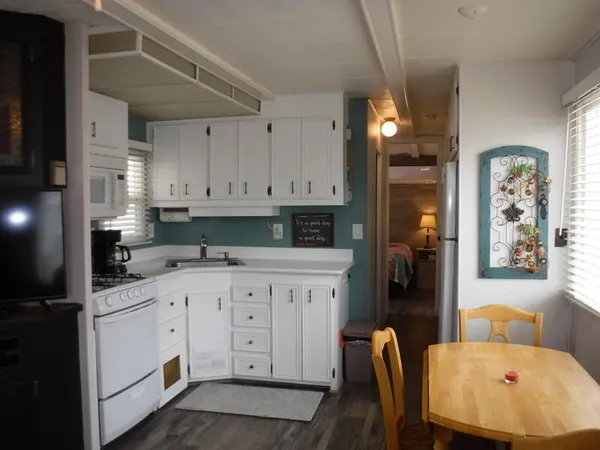 a kitchen with stainless steel appliances white cabinets sink and a refrigerator