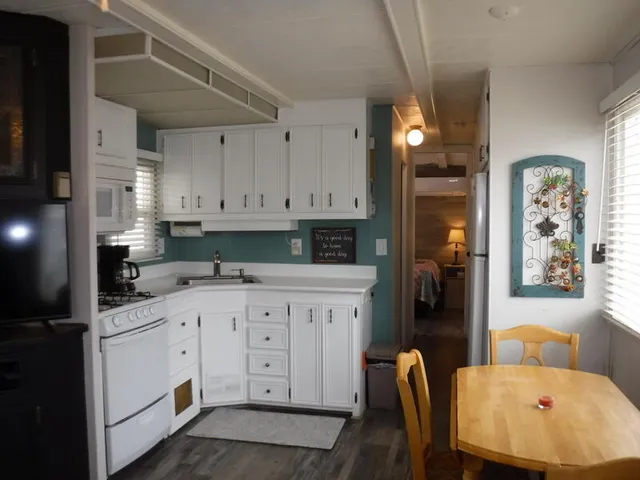 a kitchen with stainless steel appliances white cabinets sink and a refrigerator