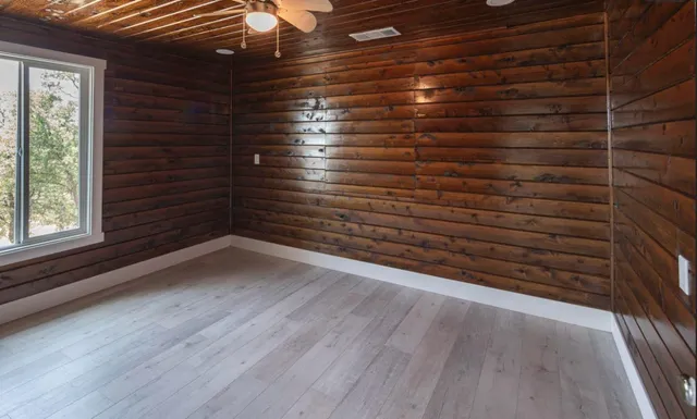 an empty room with windows and cabinet