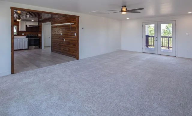 an empty room with windows ceiling fan and windows