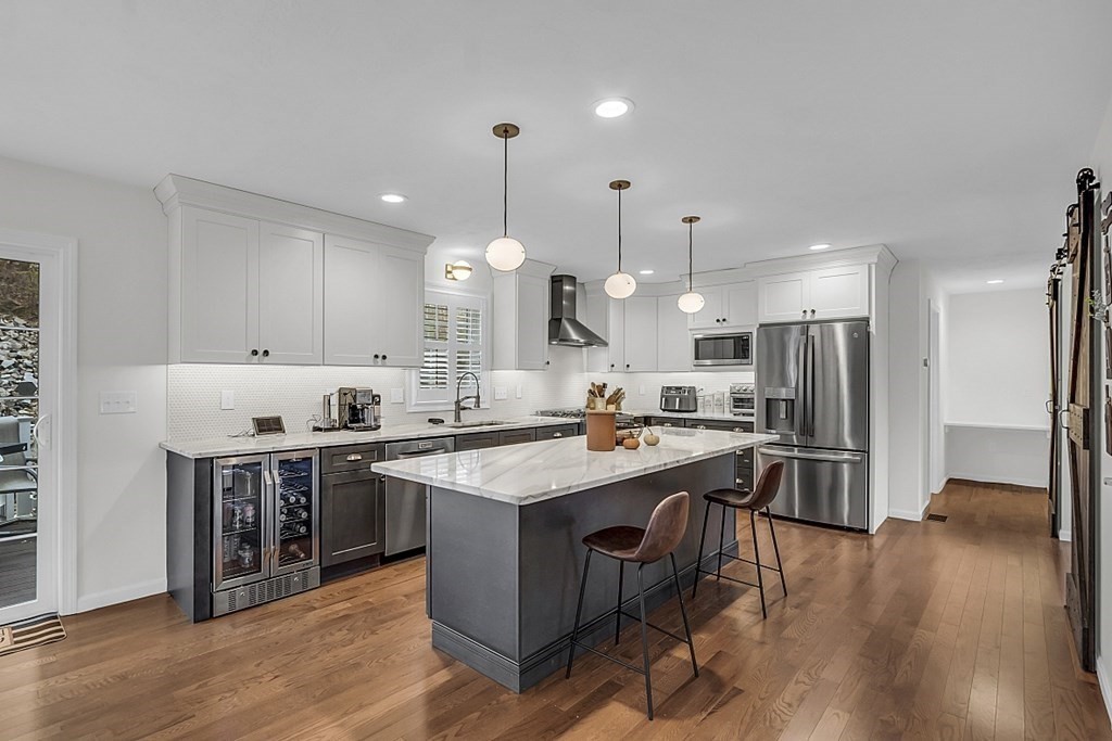 22 Paper Birch Path, Unit 36 Worcester, MA 01605 - Photo 3 of 34 a kitchen with stainless steel appliances granite countertop a sink a stove a refrigerator and a dining table with wooden floor