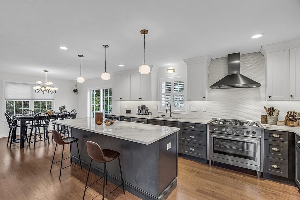 22 Paper Birch Path, Unit 36 Worcester, MA 01605 - Photo 5 of 34 a kitchen with stainless steel appliances a stove a sink a dining table and chairs with wooden floor