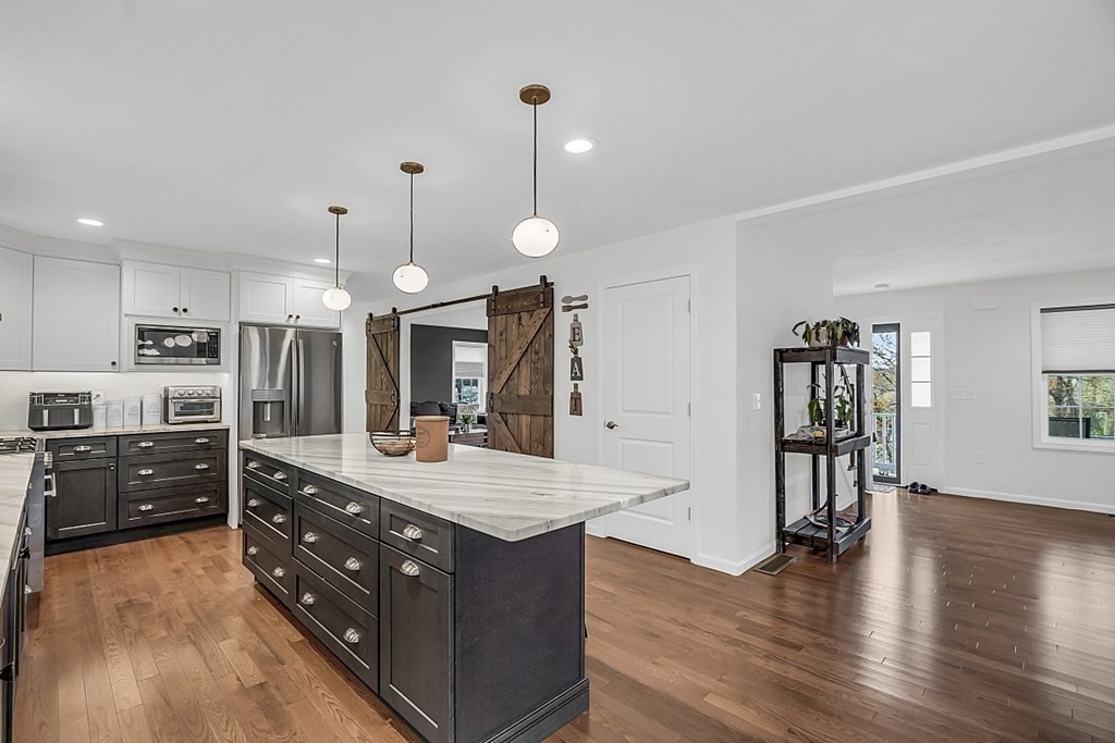 22 Paper Birch Path, Unit 36 Worcester, MA 01605 - Photo 8 of 34 a kitchen with stainless steel appliances granite countertop a refrigerator a sink dishwasher a stove and a dining table with wooden floor