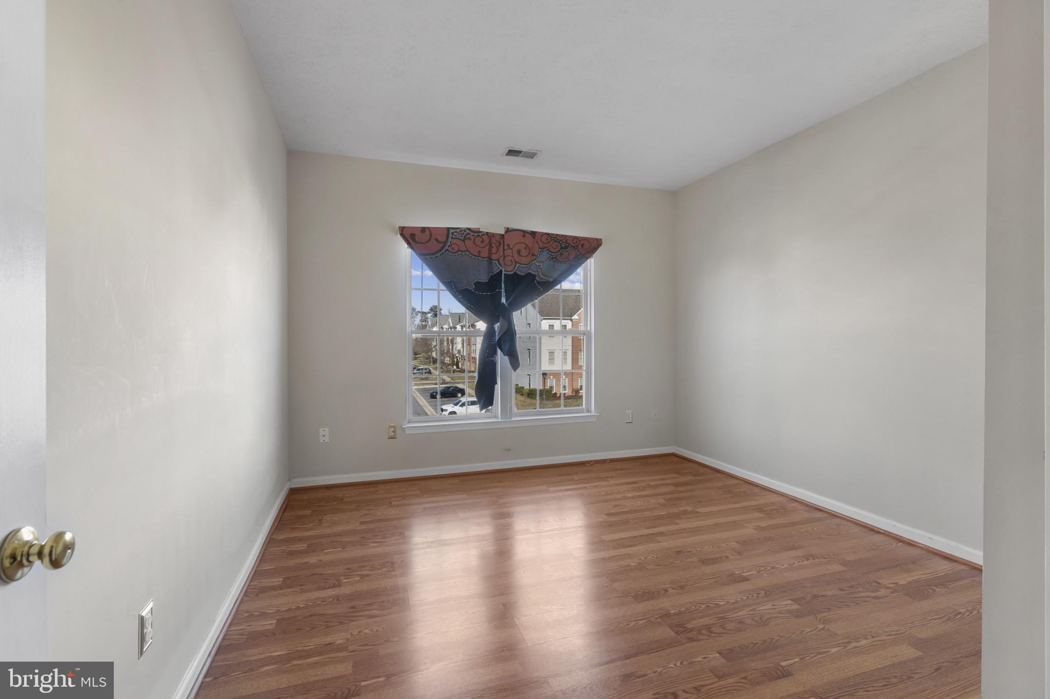 4868 Brightleaf Court, Unit 4868 Rosedale, MD 21237 - Photo 21 of 25 an empty room with wooden floor and window