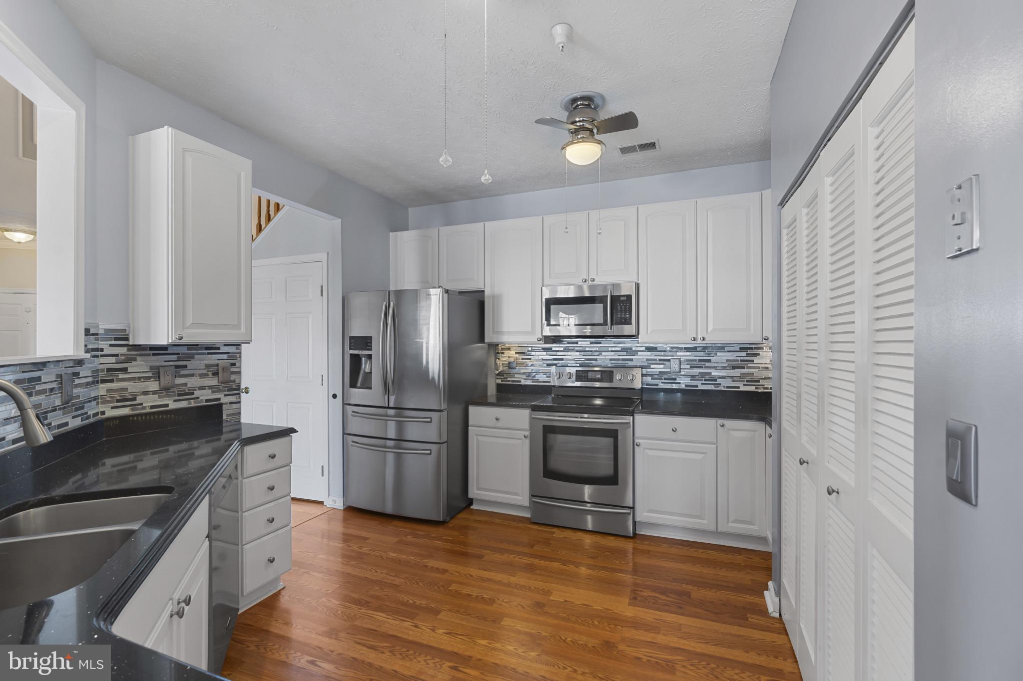 4868 Brightleaf Court, Unit 4868 Rosedale, MD 21237 - Photo 10 of 25 a kitchen with kitchen island granite countertop stainless steel appliances and wooden cabinets