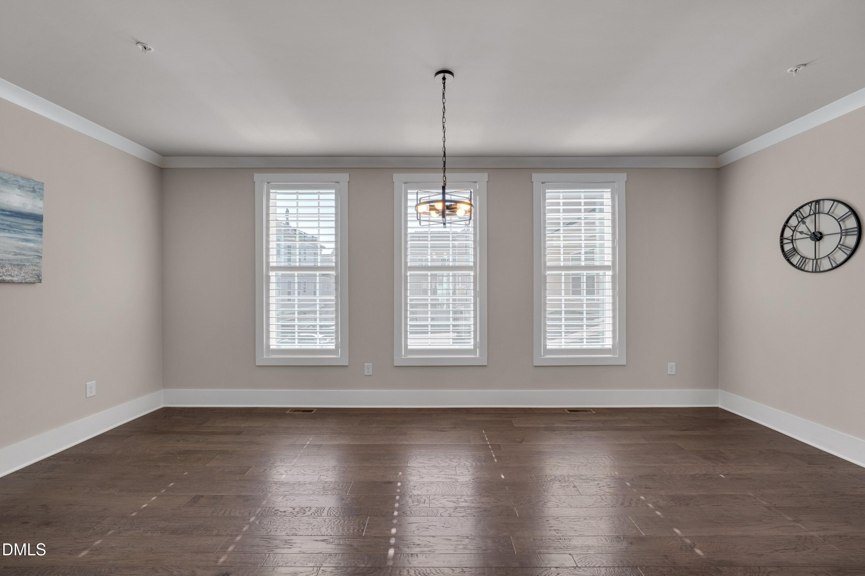 10330 Sablewood Drive, Unit 104 Raleigh, NC 27617 - Photo 7 of 28 a view of an empty room with wooden floor and a window