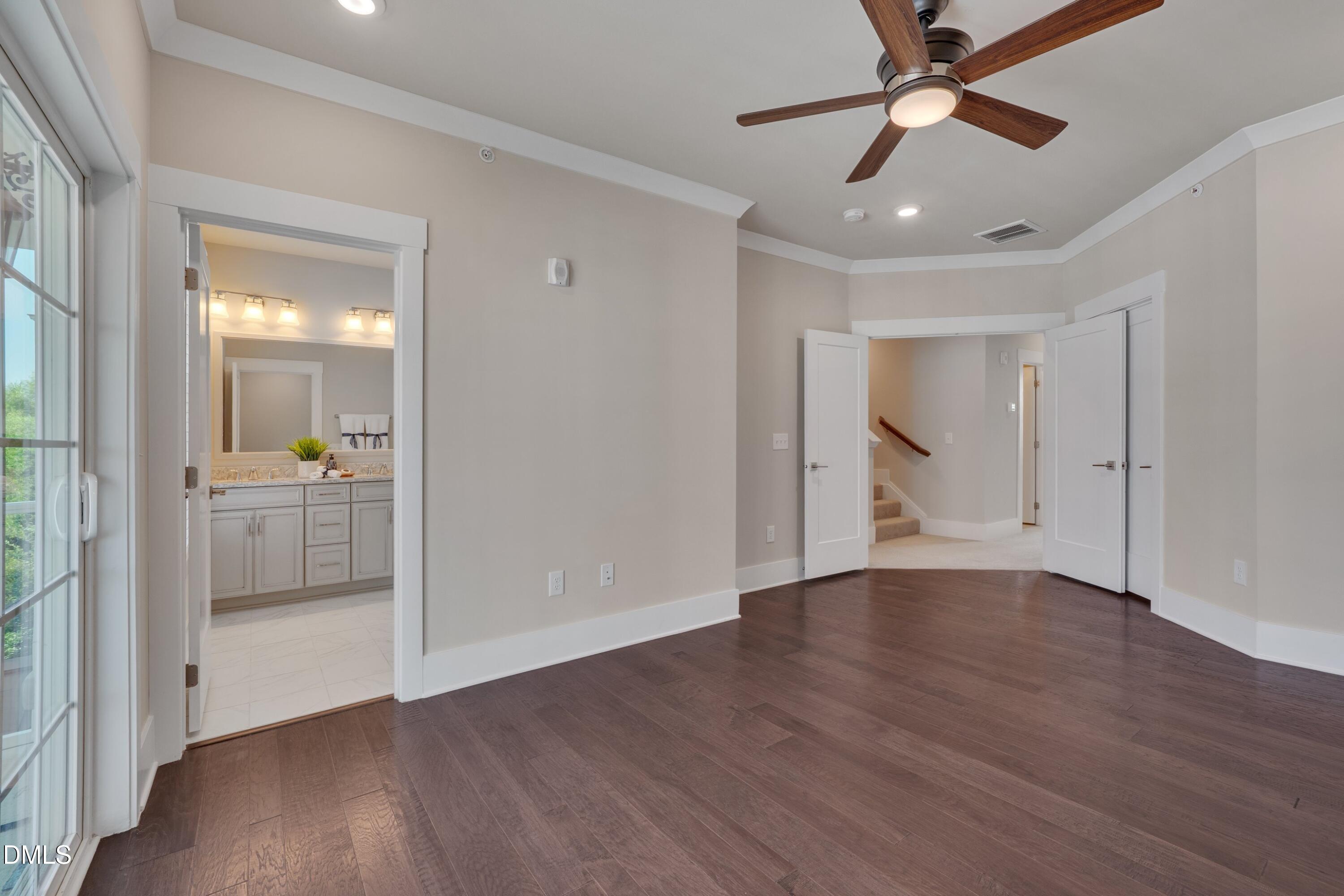 10330 Sablewood Drive, Unit 104 Raleigh, NC 27617 - Photo 10 of 28 an empty room with wooden floor a ceiling fan and a bathroom