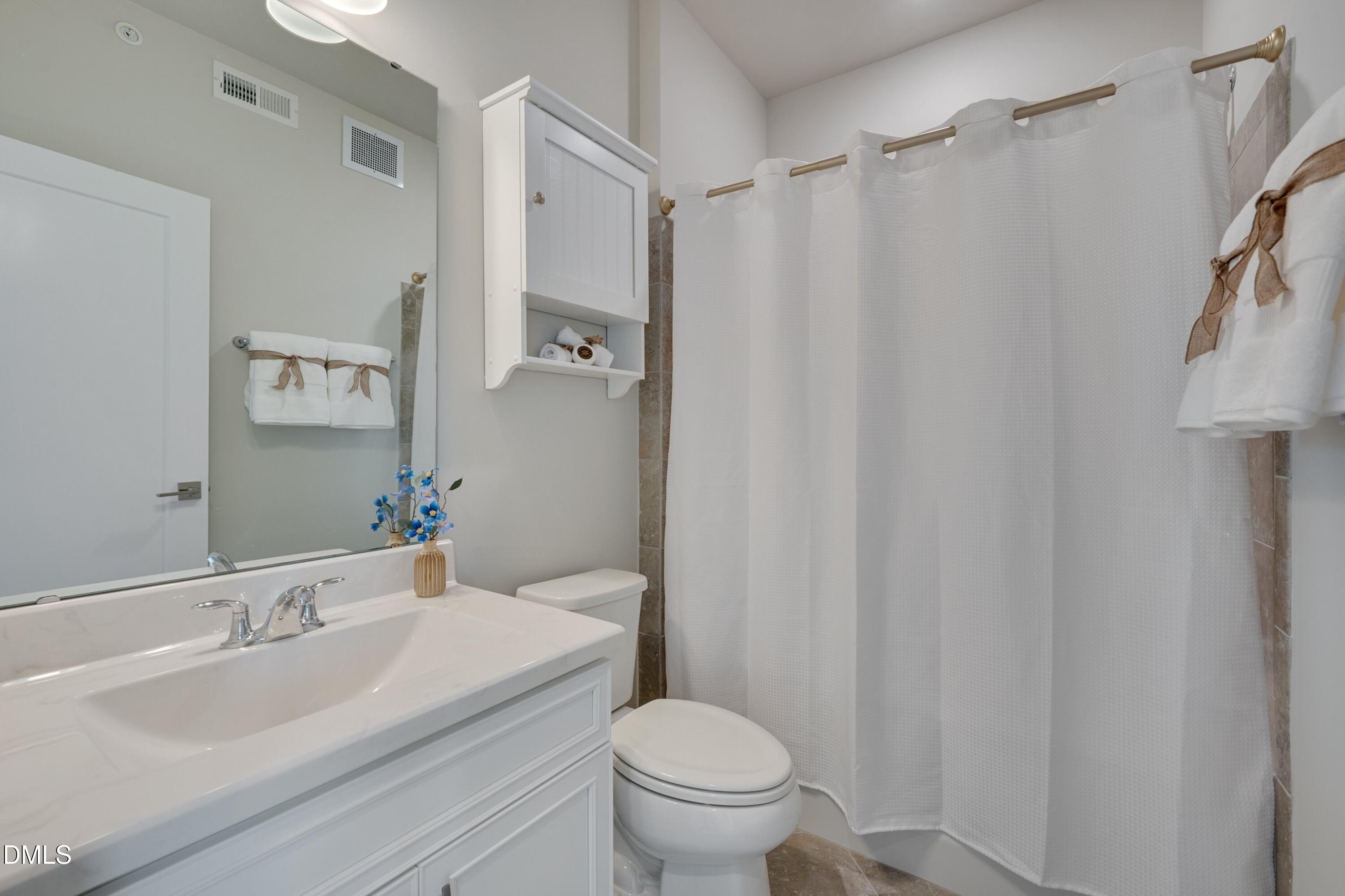 10330 Sablewood Drive, Unit 104 Raleigh, NC 27617 - Photo 14 of 28 a bathroom with a sink toilet and shower