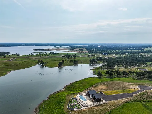 an aerial view of a house with a yard and lake view