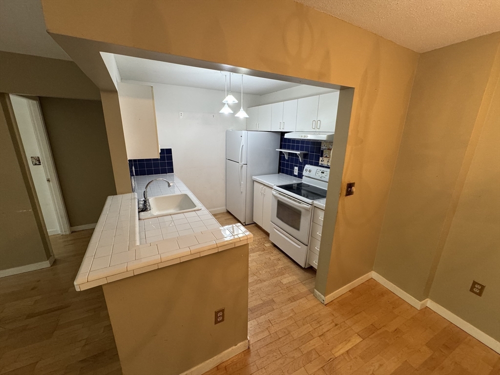 273 Cambridge Road, Unit 202 Woburn, MA 01801 - Photo 21 of 38 a kitchen with a sink and a stove top oven