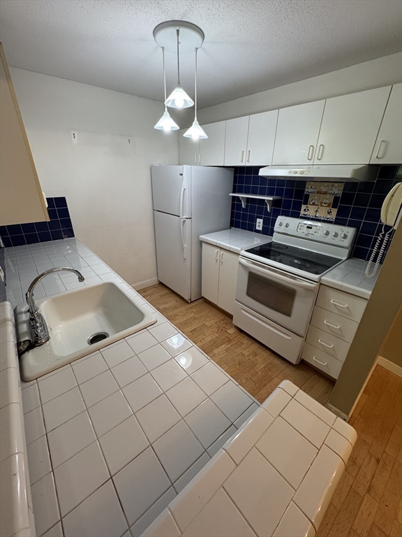 273 Cambridge Road, Unit 202 Woburn, MA 01801 - Photo 22 of 38 a kitchen with stainless steel appliances granite countertop a sink a stove and cabinets