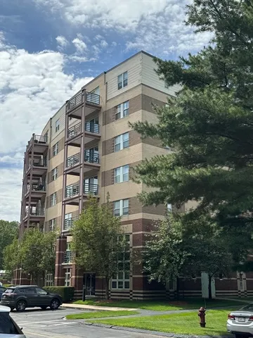 a view of a tall building next to a yard