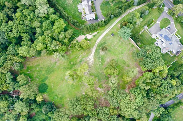 an aerial view of residential houses with outdoor space and trees