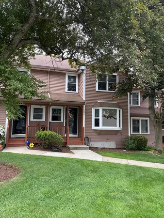 a front view of a house with a yard and trees