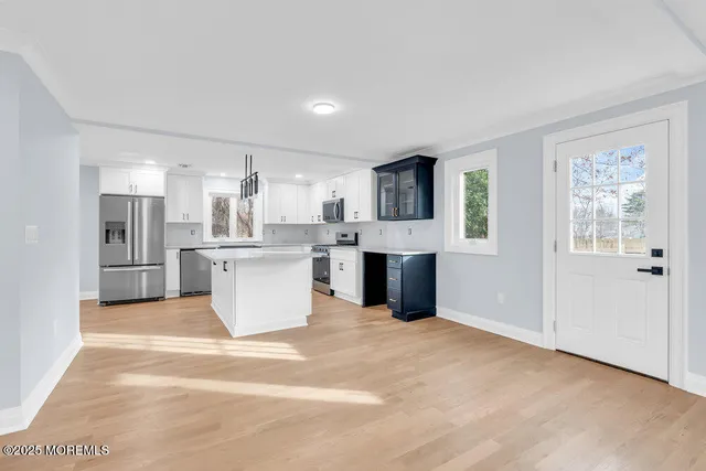 a large kitchen with kitchen island a stove a refrigerator a sink dishwasher with a dining table and chairs