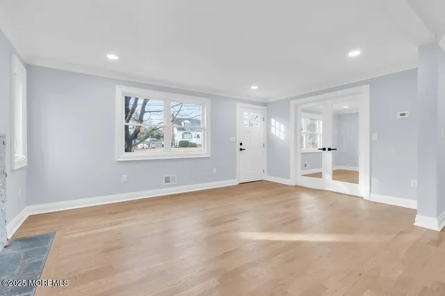 a view of empty room with wooden floor and windows