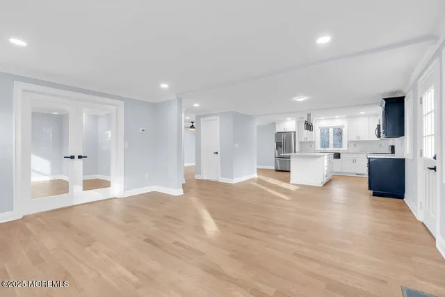 a view of a kitchen with kitchen island a sink stainless steel appliances and cabinets
