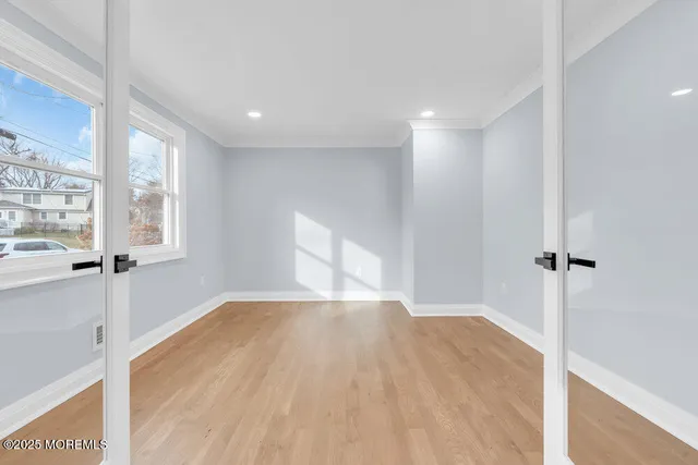 a view of a big room with wooden floor and windows