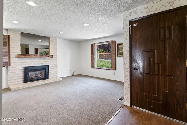 a view of a livingroom with an empty space and a fireplace