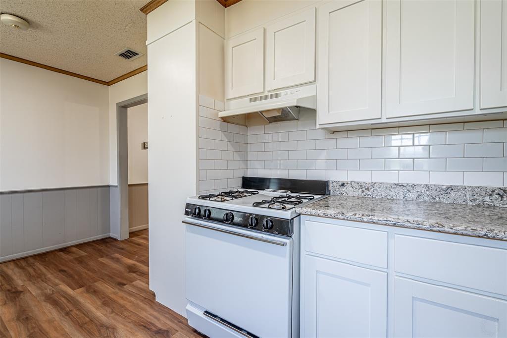 501 Endora Dublin, TX 76446 - Photo 16 of 39 a kitchen with granite countertop cabinets stainless steel appliances and a wooden floor
