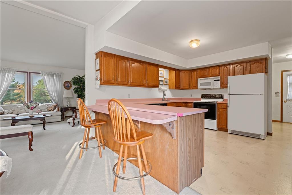 2997 Spangler Road Hermitage, PA 16148 - Photo 9 of 43 a kitchen with stainless steel appliances granite countertop a stove a refrigerator a oven a sink with a dining table and chairs