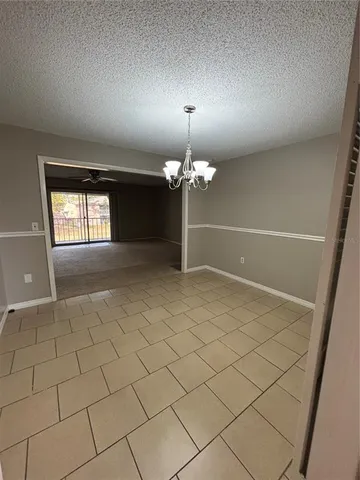 a view of a livingroom with a chandelier fan and window