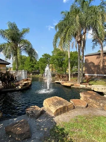 a view of a lake with lawn chairs under an umbrella