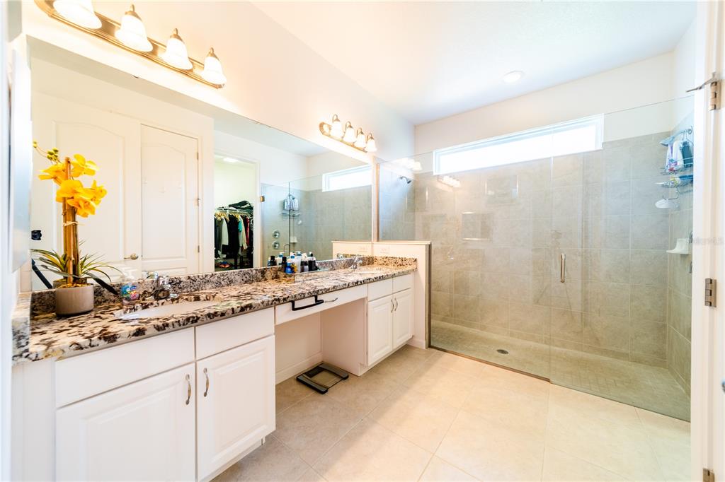 4027 Oakrise Loop Davenport, FL 33837 - Photo 29 of 66 a bathroom with a shower sink and mirror